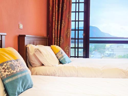 deux lits dans une chambre avec une fenêtre dans l'établissement Lancasa Taitung, à Taïtung