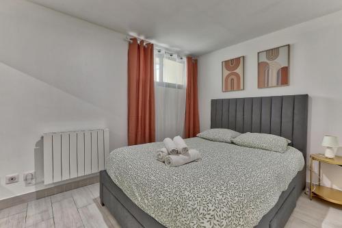 une chambre avec un lit avec un ours en peluche dessus dans l'établissement Magnifique appartement proche de Paris, à Villejuif