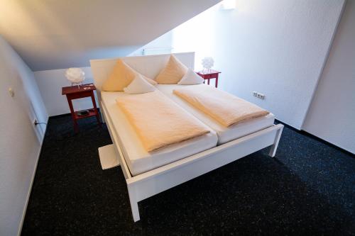 a white bed in a room with two tables at BurgStadt-Hotel in Kastellaun