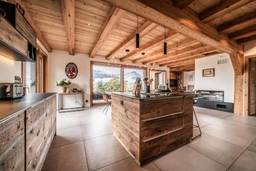 - une cuisine avec des murs en bois et un grand îlot en bois dans l'établissement Coeur de mélèze, à Thyez