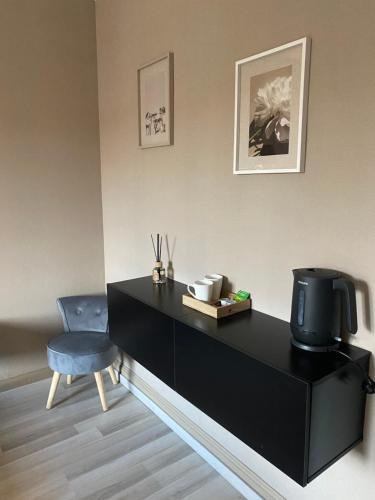 a black desk with a chair and a television at Chambres Dancourt in Charmes