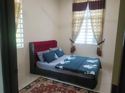 a bed sitting in a room with two windows at Homestay d fattah jitra menawarkanpotongan diskaun in Jitra