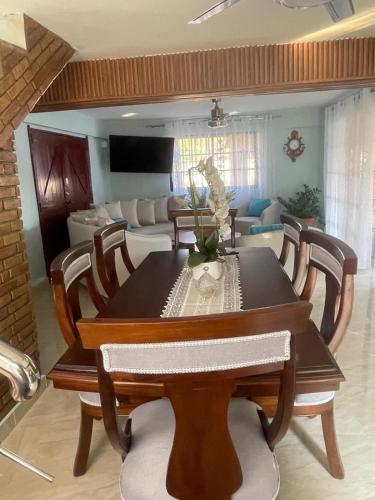 a dining room with a table and a couch at Villa Rosa Bella Perfect for families or groups in Palmar de Ocoa