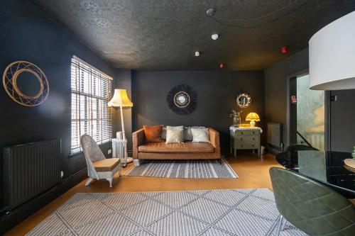 a living room with a couch and a chair at GuestReady - Rose and Monkey Hotel in Manchester