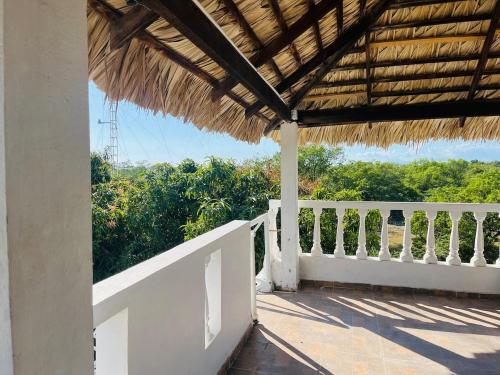 a porch of a house with a straw roof at Villa Rosa Bella Perfect for families or groups in Palmar de Ocoa