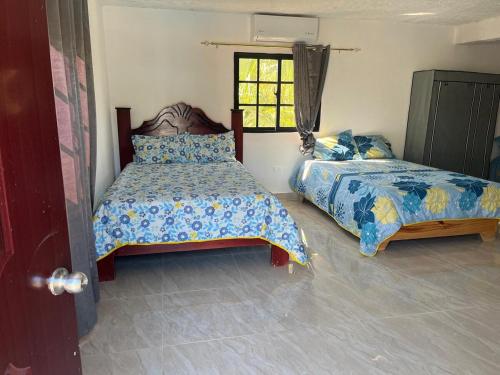 a bedroom with two beds and a window at Villa Rosa Bella Perfect for families or groups in Palmar de Ocoa