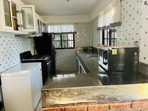 a kitchen with a counter top and a microwave at Villa Rosa Bella Perfect for families or groups in Palmar de Ocoa