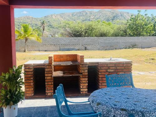 a brick fireplace with a table and chairs on a patio at Villa Rosa Bella Perfect for families or groups in Palmar de Ocoa