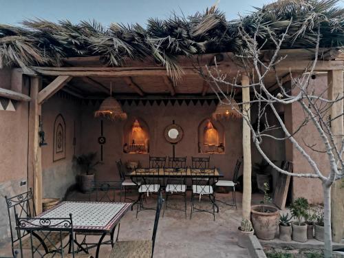 a group of tables and chairs in a patio at Maison d'hôte tamatart - Homestay in Kalaat MGouna