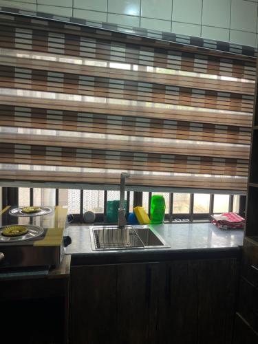 a kitchen counter with a sink and a window at Peridot Studio Apt maitama in Abuja