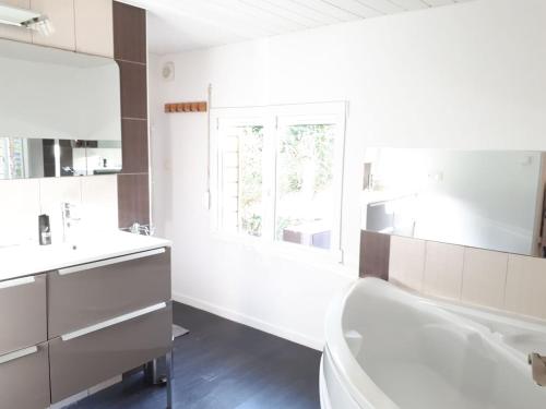 une salle de bain avec une baignoire, des toilettes et un lavabo dans l'établissement Maison au calme sur grand terrain avec piscine, à Saint-Vivien-de-Médoc