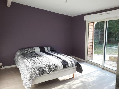 une chambre avec un lit et une grande fenêtre dans l'établissement Maison au calme sur grand terrain avec piscine, à Saint-Vivien-de-Médoc