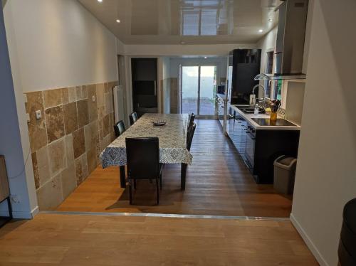 une cuisine avec une table et des chaises dans une pièce dans l'établissement Maison au calme sur grand terrain avec piscine, à Saint-Vivien-de-Médoc