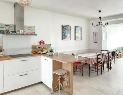 une cuisine et une salle à manger avec une table et des chaises dans l'établissement Maison charmante avec vue sur la mer à Fouras, à Fouras