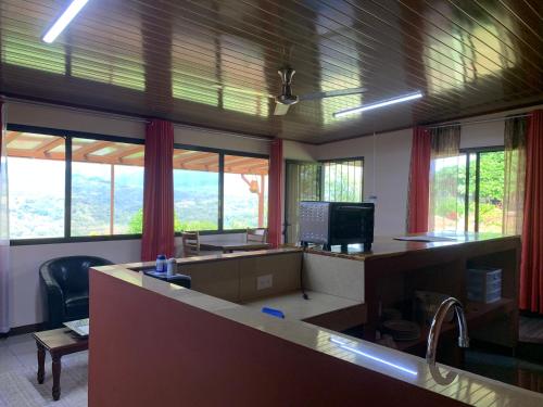 an office with a desk with a computer and windows at Conectar con la naturaleza in Esparza