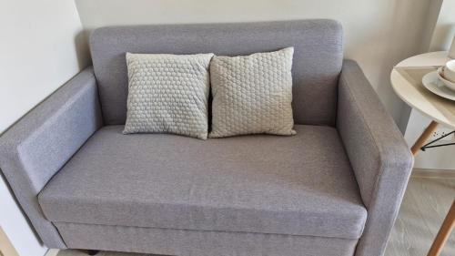 a gray chair with a pillow on top of it at GM Asset in Ban Lat Krachaeng