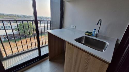 a kitchen with a sink and a large window at GM Asset in Ban Lat Krachaeng