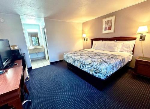 a hotel room with a bed and a television at Red Carpet Inn - Stamford in Stamford
