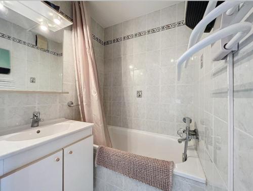 a white bathroom with a sink and a bath tub at Studio Le Flocon à Saint-Gervais-les-Bains in Saint-Gervais-les-Bains