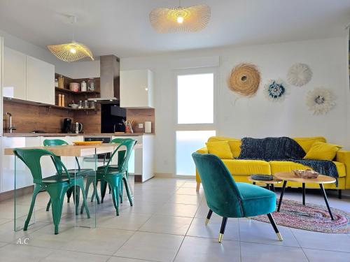 - un salon avec un canapé jaune, une table et des chaises dans l'établissement La Ciccia - appartement cosy de plain-pied, avec jardin, terrasse et garage privé - By AURAconcergerie, à Saint-Cyr-sur-Mer