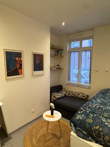 Cette chambre comprend un lit, un canapé et une table. dans l'établissement Appartement Idéal Proche Gare, à Amiens
