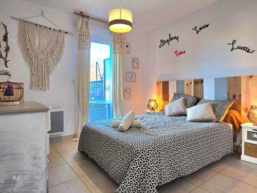 - une chambre dotée d'un lit avec des mots sur le mur dans l'établissement La Ciccia - appartement cosy de plain-pied, avec jardin, terrasse et garage privé - By AURAconcergerie, à Saint-Cyr-sur-Mer