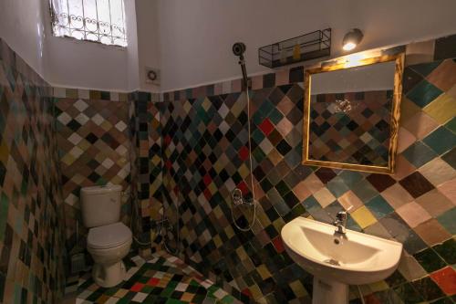 a bathroom with a sink and a toilet and a mirror at Riad Yamna Fez in Fès