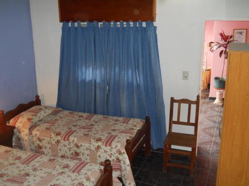 a bedroom with a bed and a blue curtain at Dennisse Hotel in Victoria