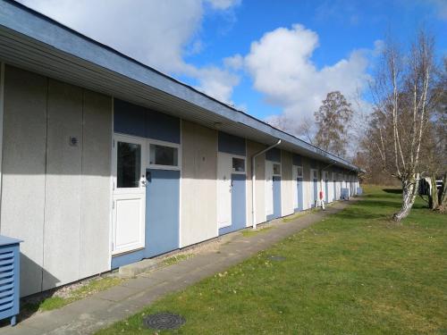 a building with white and blue doors on it at Gemütliche Wohnung in Strandnähe in Neksø