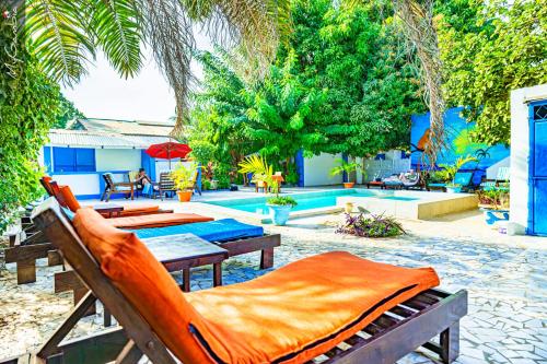 a patio with tables and chairs and a pool at Mango Lodge Gambia in Brufut