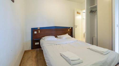 a bedroom with a large bed with white sheets and towels at Vacancéole - Appart'Vacances Pyrénées 2000 in Bolquere Pyrenees 2000