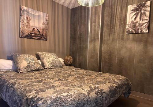 a bedroom with a bed and two pictures on the wall at Appartement d'exception & accès direct plage in Palavas-les-Flots