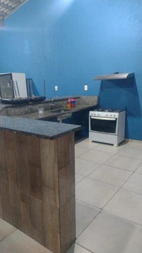 a kitchen with a stove and a blue wall at Clube com Piscina in Andradina