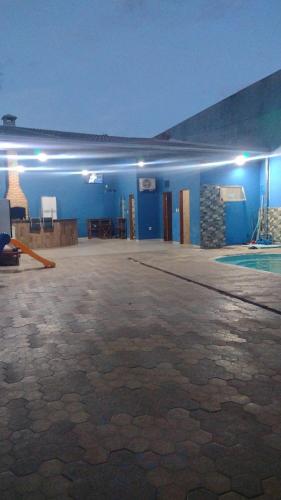 a room with a swimming pool and a blue wall at Clube com Piscina in Andradina