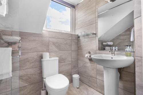 a bathroom with a white toilet and a sink at The Lansdowne in Leamington Spa
