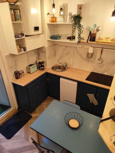 une petite cuisine avec une table et un évier dans l'établissement Appartement Place des Eaux Bonnes, à Eaux-Bonnes