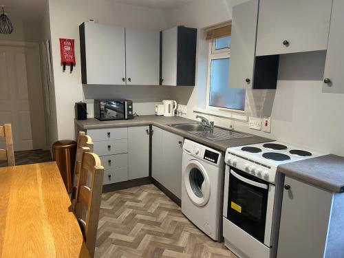 a kitchen with a stove and a washing machine at Bienvenue in Hyde Park