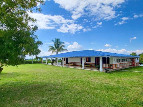 a building with a blue roof in a field at Finca Nuevo Monarca in Pereira