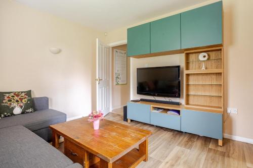 a living room with a couch and a tv at Bienvenue in Hyde Park