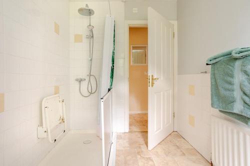 a white bathroom with a shower and a toilet at Bienvenue in Hyde Park