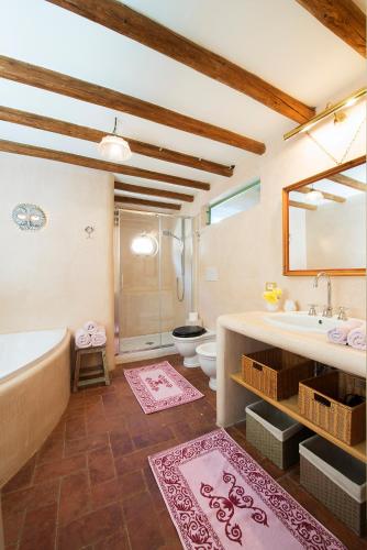 a bathroom with a tub and a sink and a toilet at I Magazzini in Marti