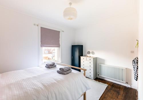 a white bedroom with a bed and a window at Harvieston in Elie