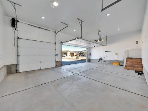 an empty garage with white walls and concrete floors at Timeless Hive in Parowan
