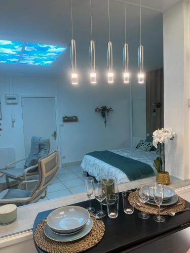 - une chambre avec un lit et une table avec des assiettes et des verres dans l'établissement Studio le Végétal, à Châlons-en-Champagne