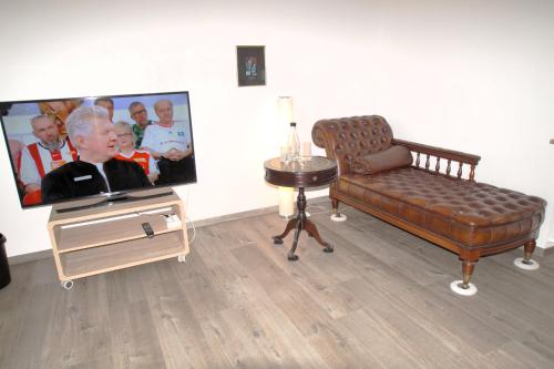 a living room with a tv and a couch and a table at Ruhepol in Wiesloch
