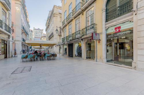 an empty street with tables and chairs in a city at Hotel Duas Nações in Lisbon