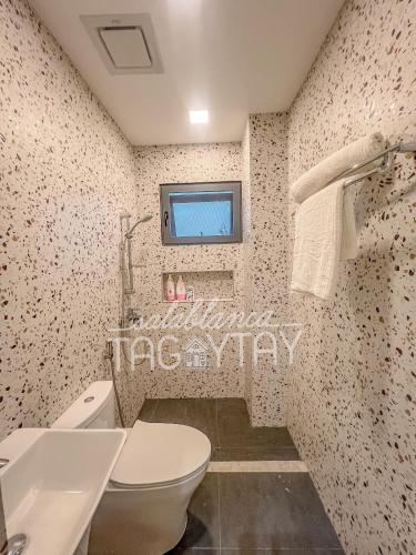 a bathroom with a toilet and a sink at Salablanca Brand New Jacuzzi Heated Pool PS5 VR Cinema Fully AC Indoors Smart TVs with Netflix Disney Plus Large Balcony in Tagaytay