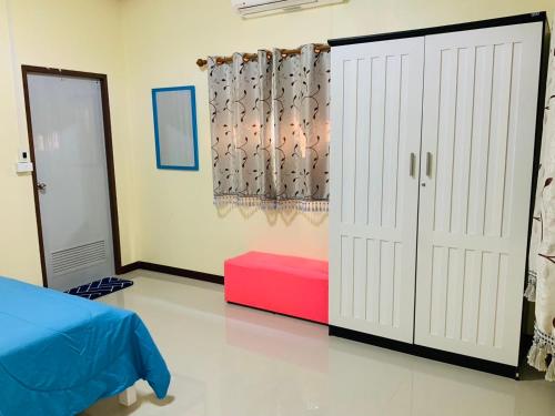 a bedroom with a bed and a door and a red box at นิลแลนด์ รีสอร์ท in Ban Tha Dan
