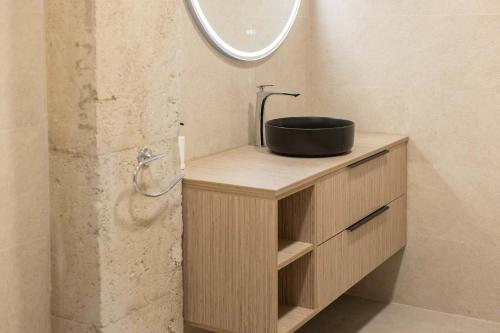 a bathroom with a sink on a wooden vanity with a mirror at Luxury Apartments Oceanografic in Valencia