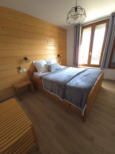 a bedroom with a bed with a wooden wall at Les Tilleuls de Chapareillan Chambres d'hôtes in Chapareillan